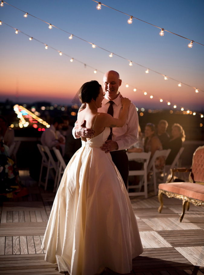 a father and bride dancing on a the terrace