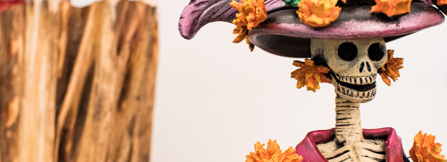 a statue of a skeleton wearing a hat and flowers