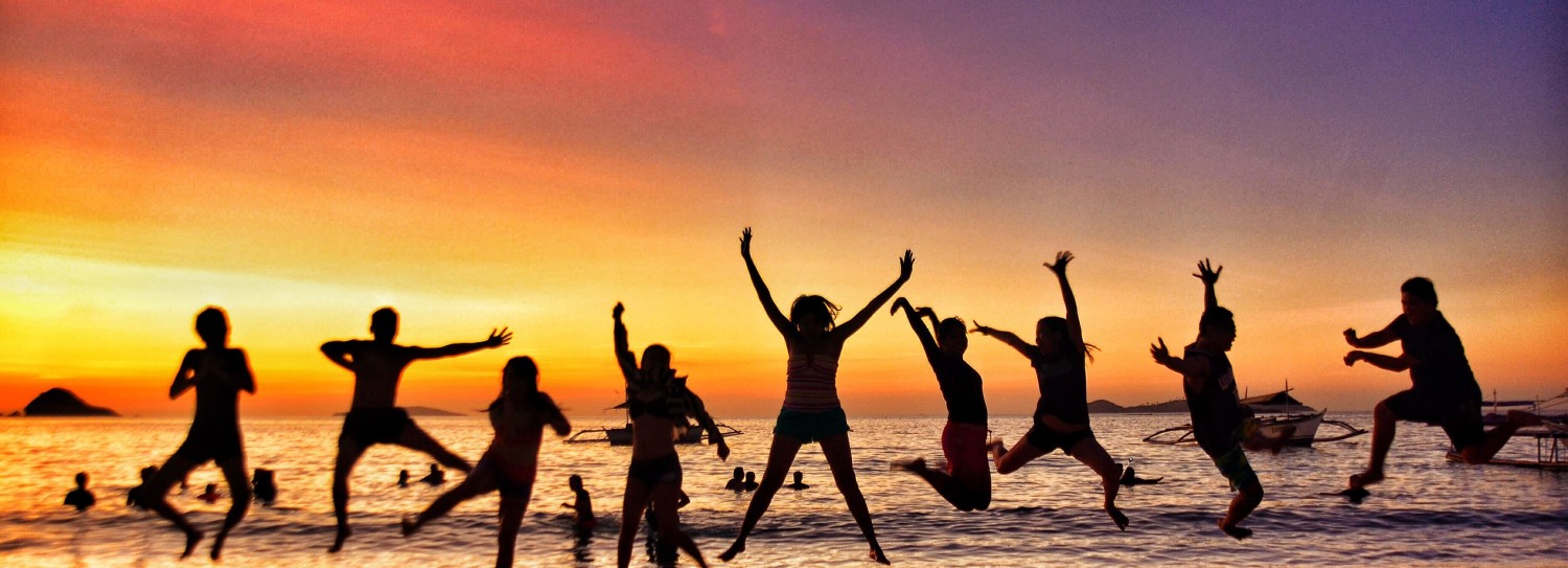 a group of people jumping on a beach