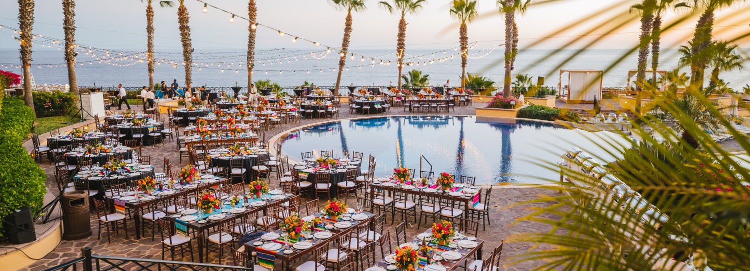 a pool with tables and chairs and palm trees