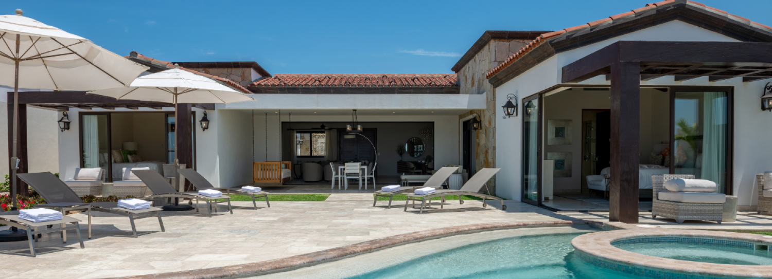 a pool with chairs and a deck chair in front of a house