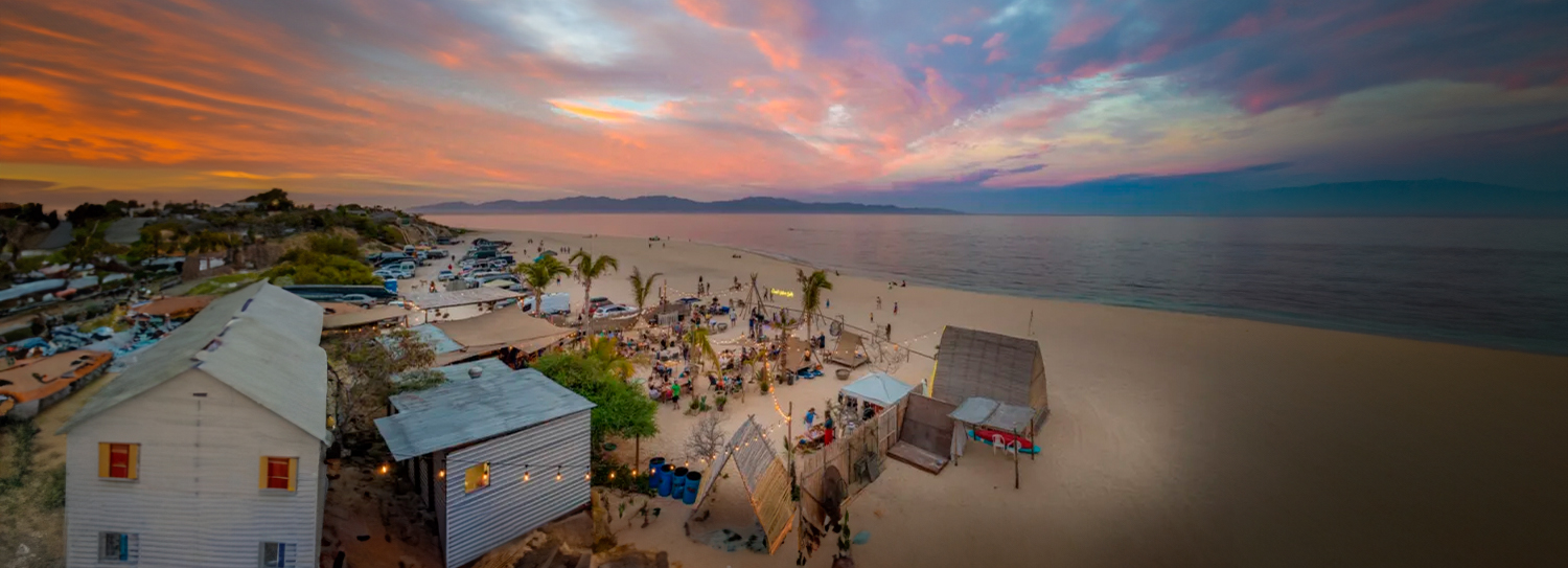 a beach with a group of people and cars