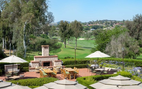 a patio with a fireplace and a golf course