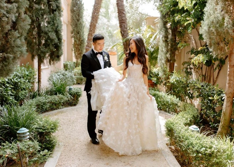 a man and woman walking down a path in a garden