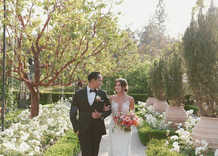 a man and woman posing for a picture in a garden