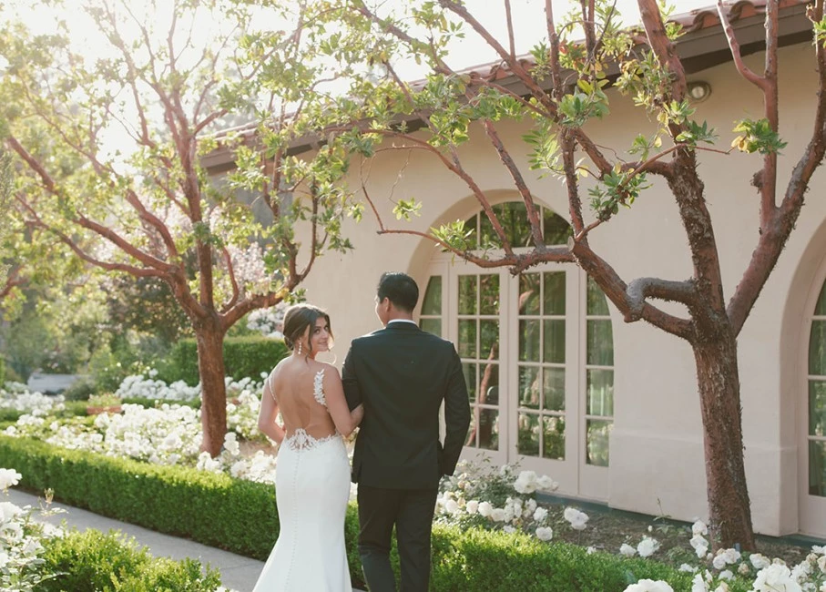 a man and woman walking down a sidewalk in front of a house