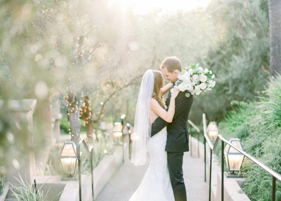 a man and woman kissing on a bridge