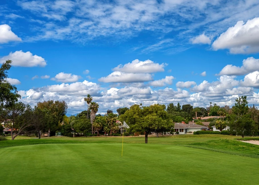 blue skies with a few clouds creating some shade over the golf course on the property