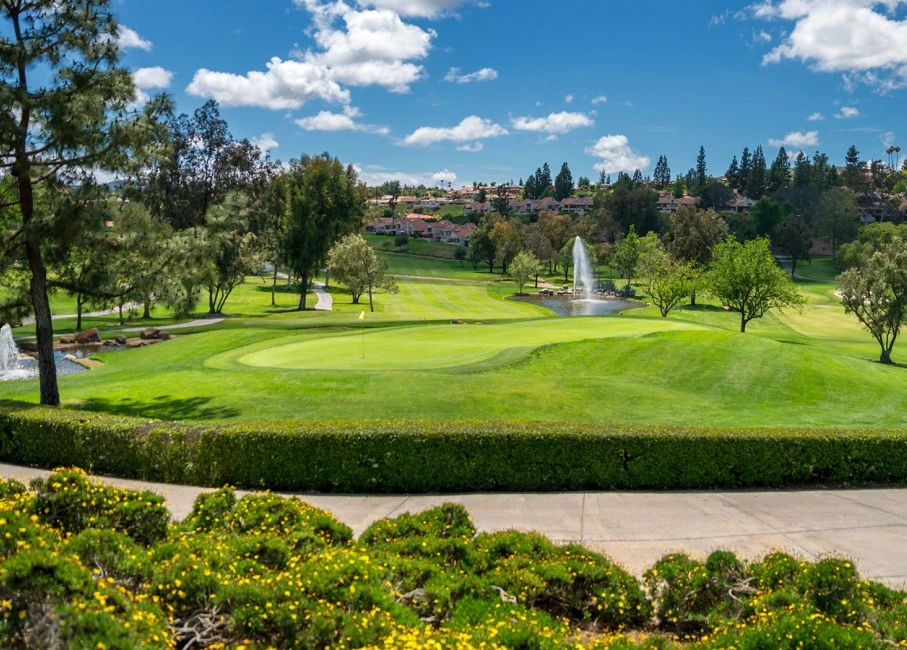 large golf course with lots of trees and water fountains