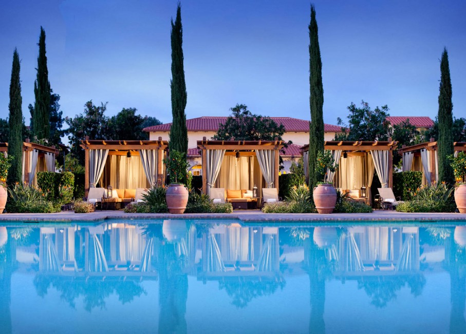 view of the pool and the cabanas during the evening