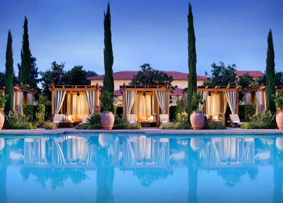 view of the pool and the cabanas during the evening
