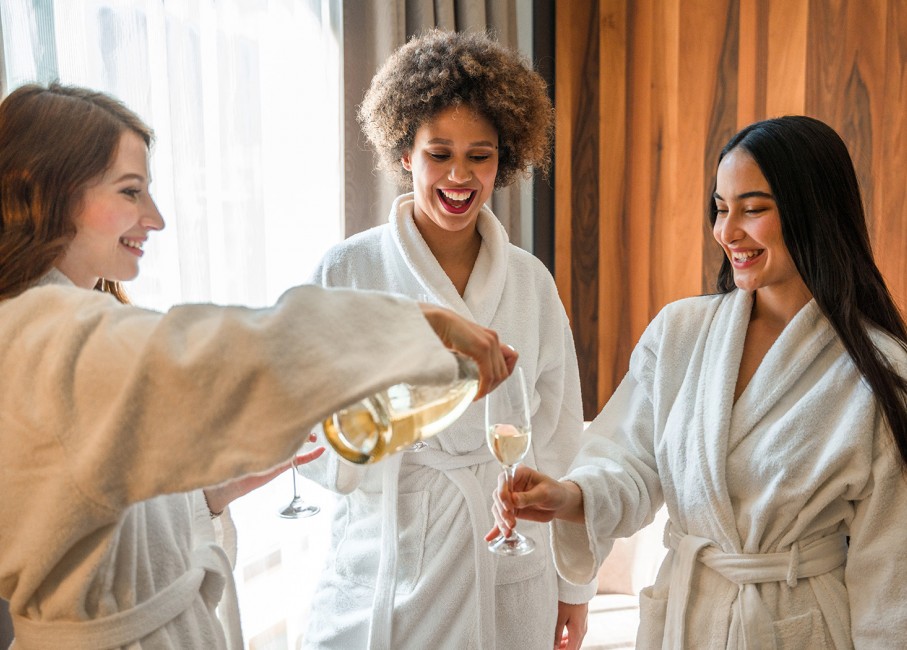 3 women smiling while getting champagne
