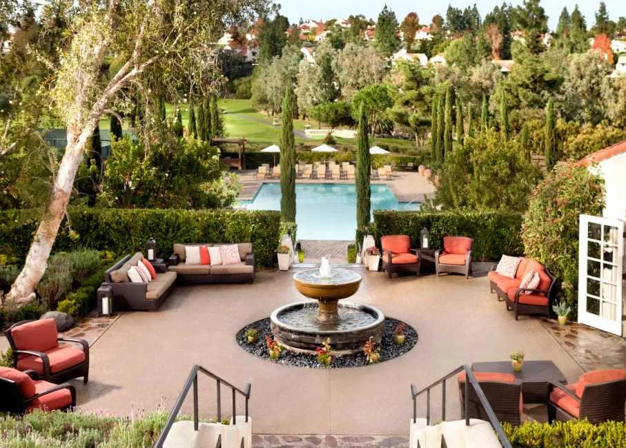 seating area set up near and around the pool and the water fountain