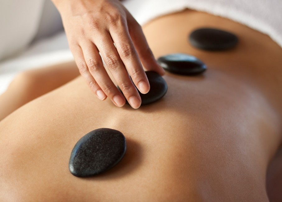 person placing hote stones on persons back