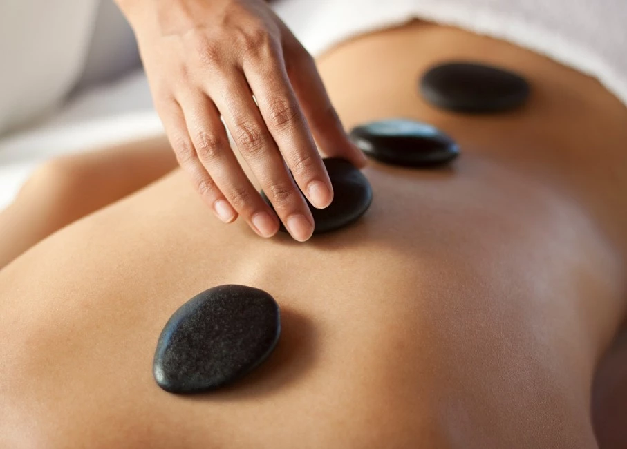 person placing hote stones on persons back