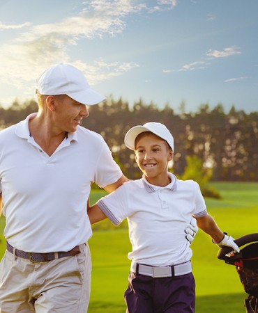 father and son walking on gold course