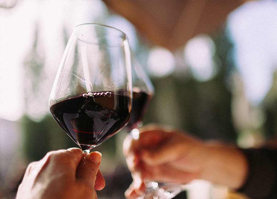 2 people toasting with red wine