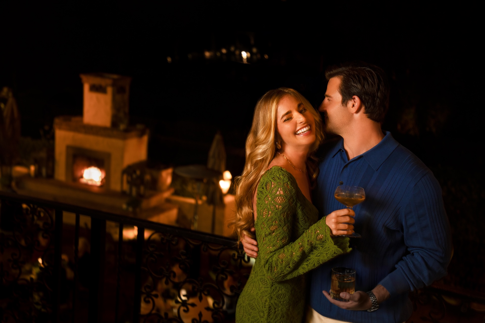 a man and woman holding drinks and smiling at each other