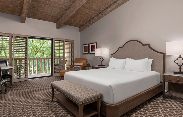 hotel bedroom with a king bed and a balcony