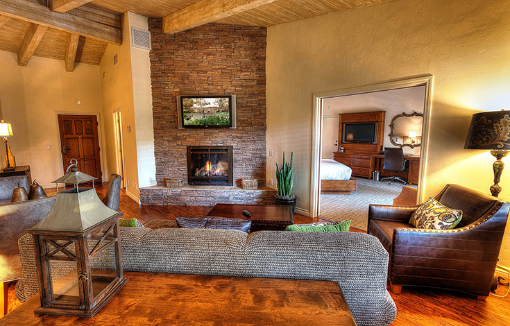 living room with a fireplace surrounded by brick