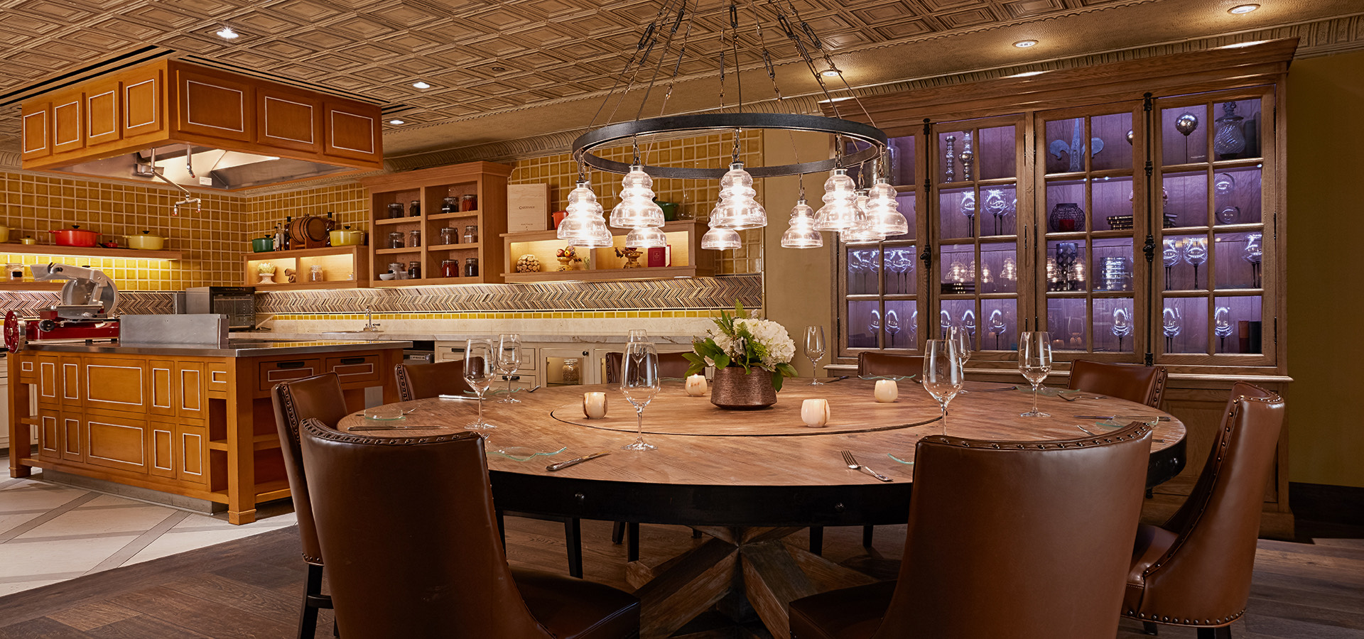 large round wooden table with kitchen in background