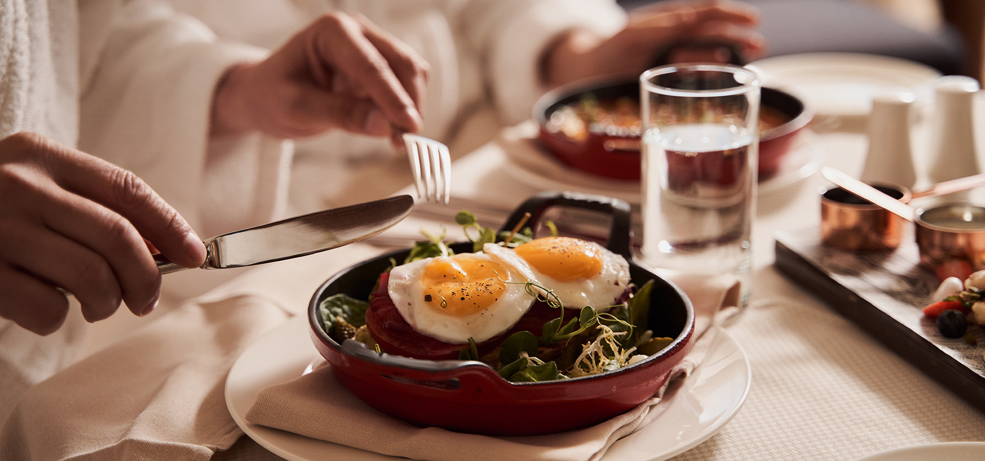 person about to out into platter with fried eggs
