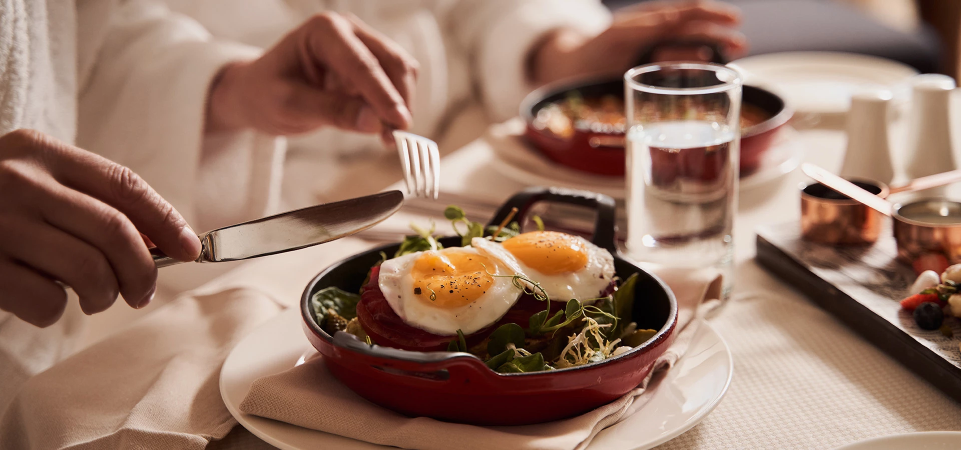 person about to out into platter with fried eggs