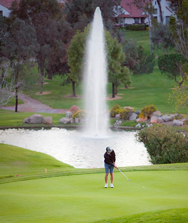 man playing golf in front of a water fountain