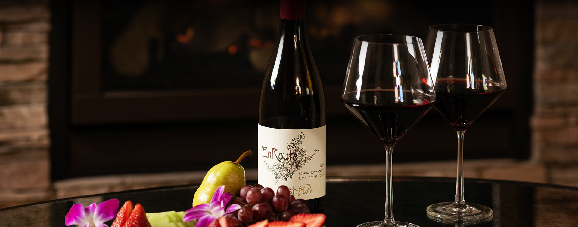 a glass of red wine, bottle and fruits