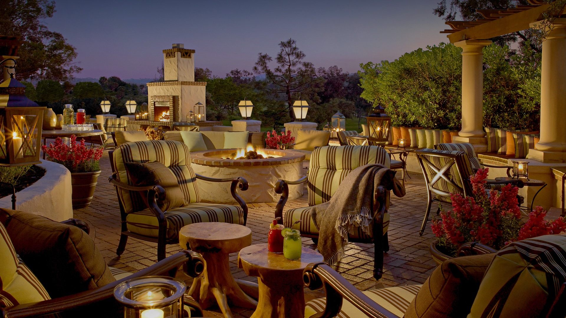 a patio with chairs and a fire pit