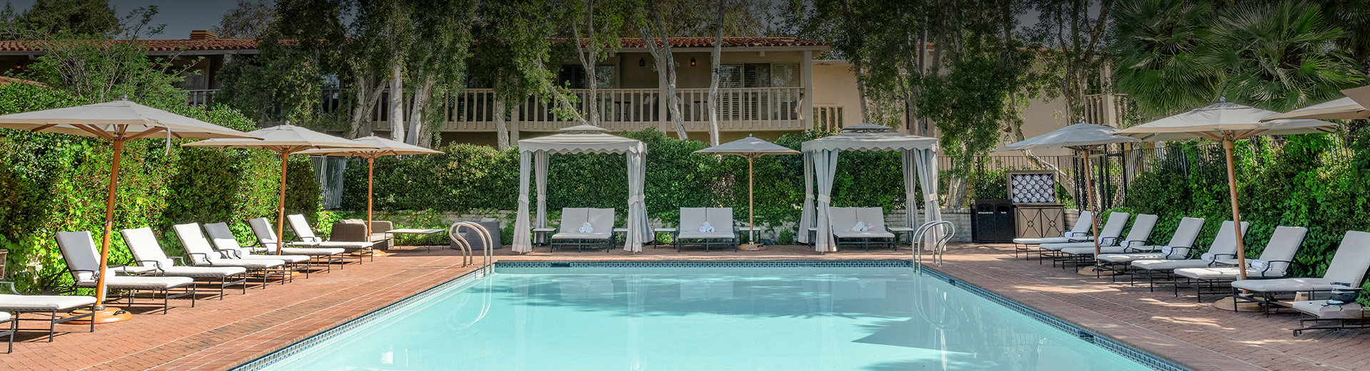 a pool with lounge chairs and umbrellas