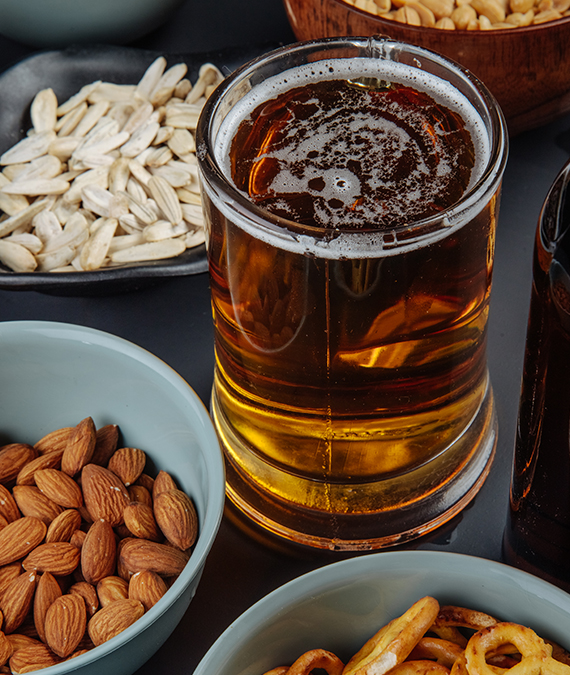 a glass of beer and nuts