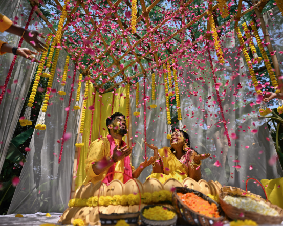 a man and woman under a canopy with flowers