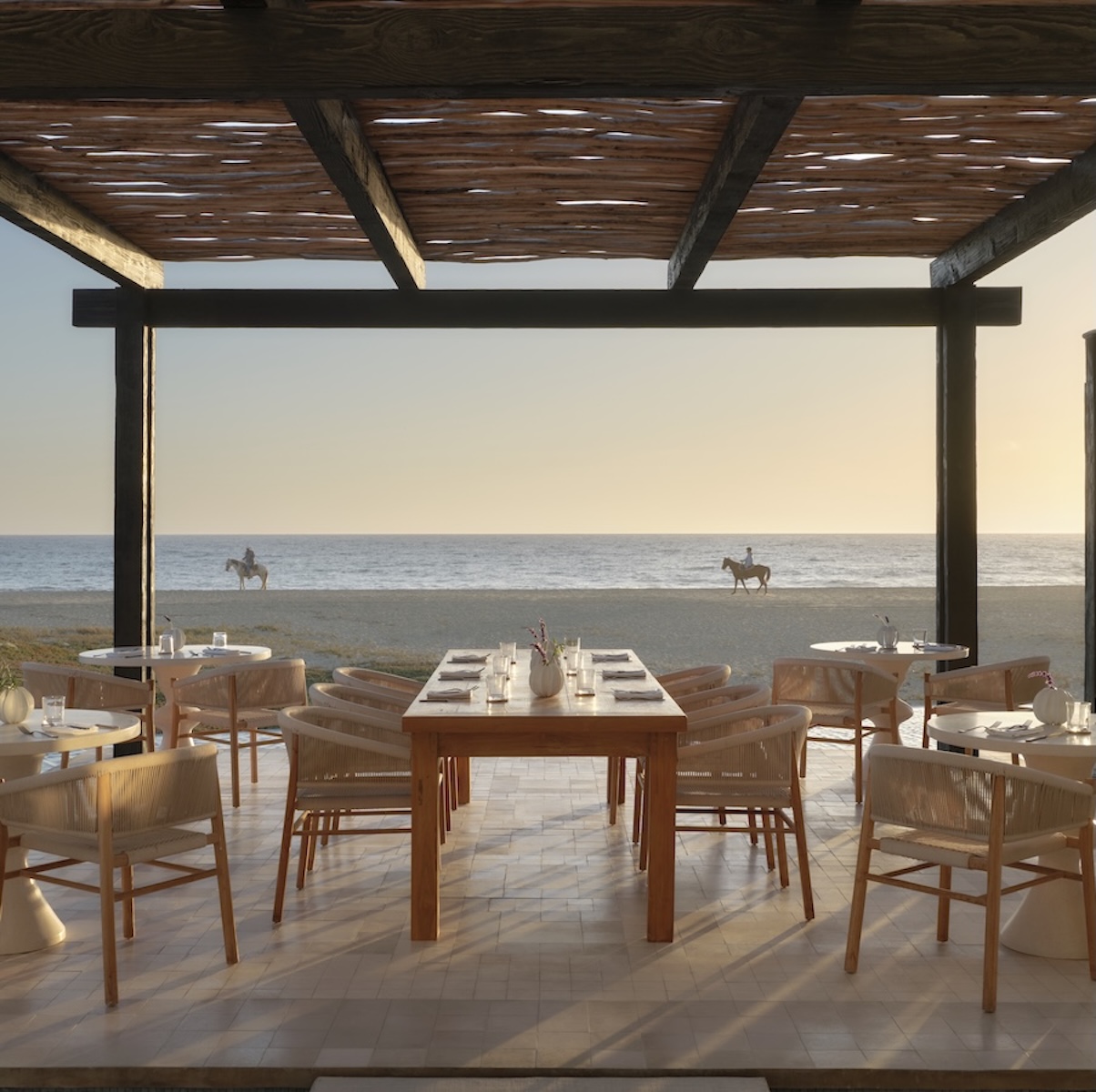 a restaurant with tables and chairs on the beach