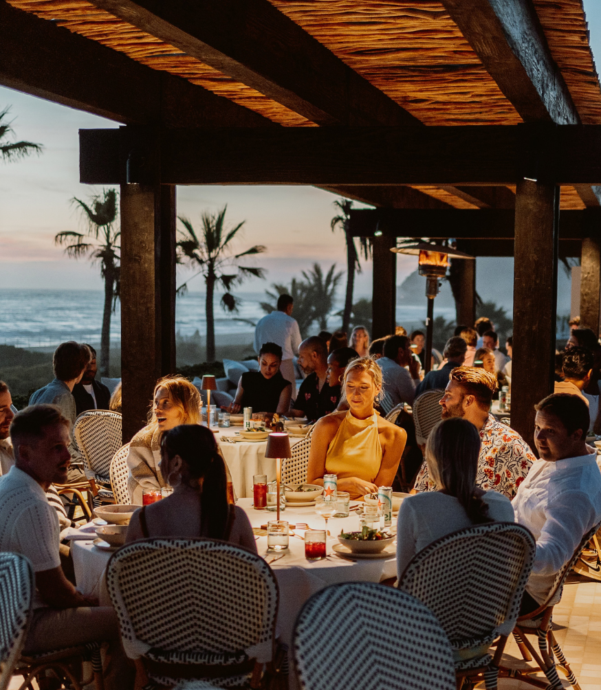 a group of people sitting at tables outside