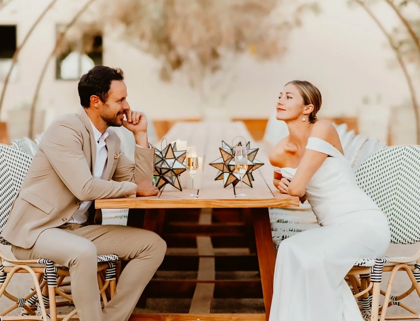 bride and groom looking at each other sitting on a table