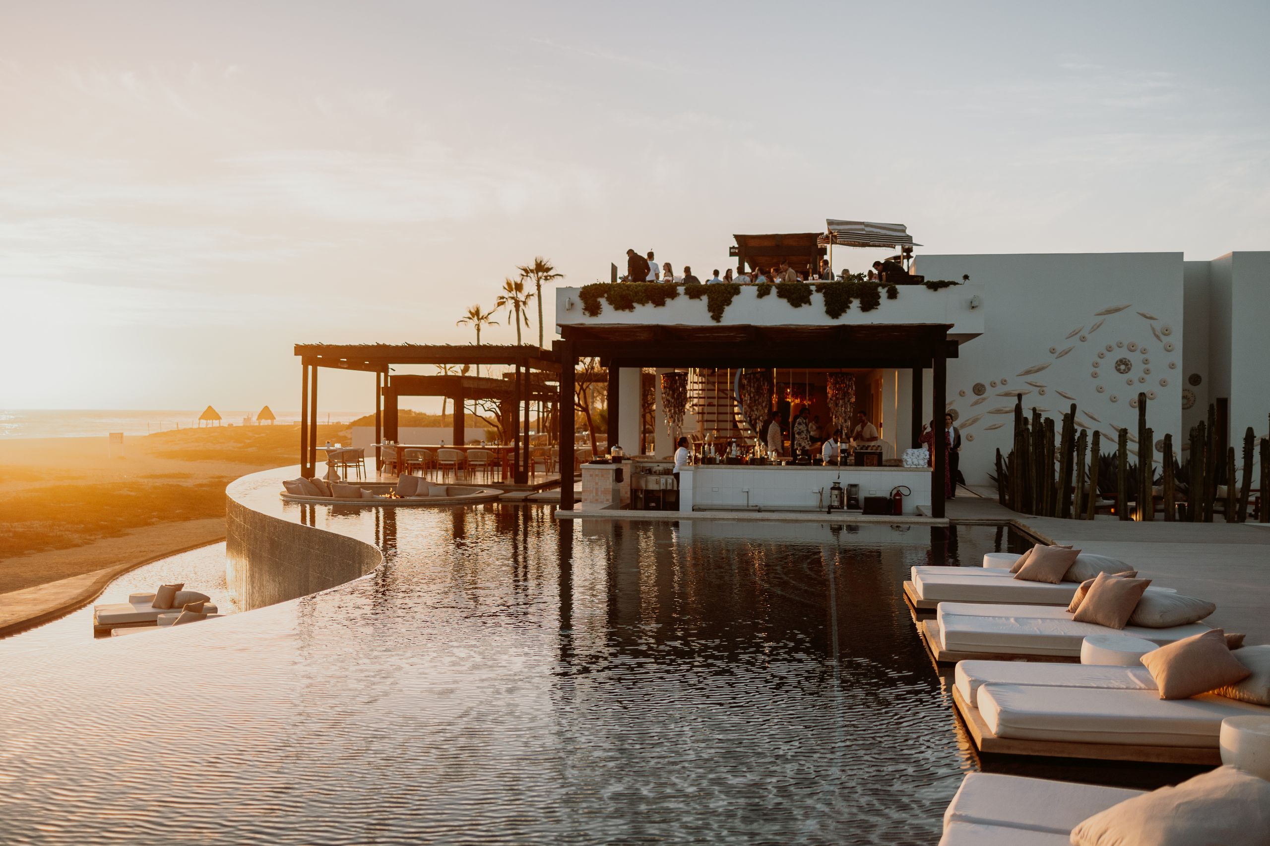 a pool with a bar and lounge chairs on top of it