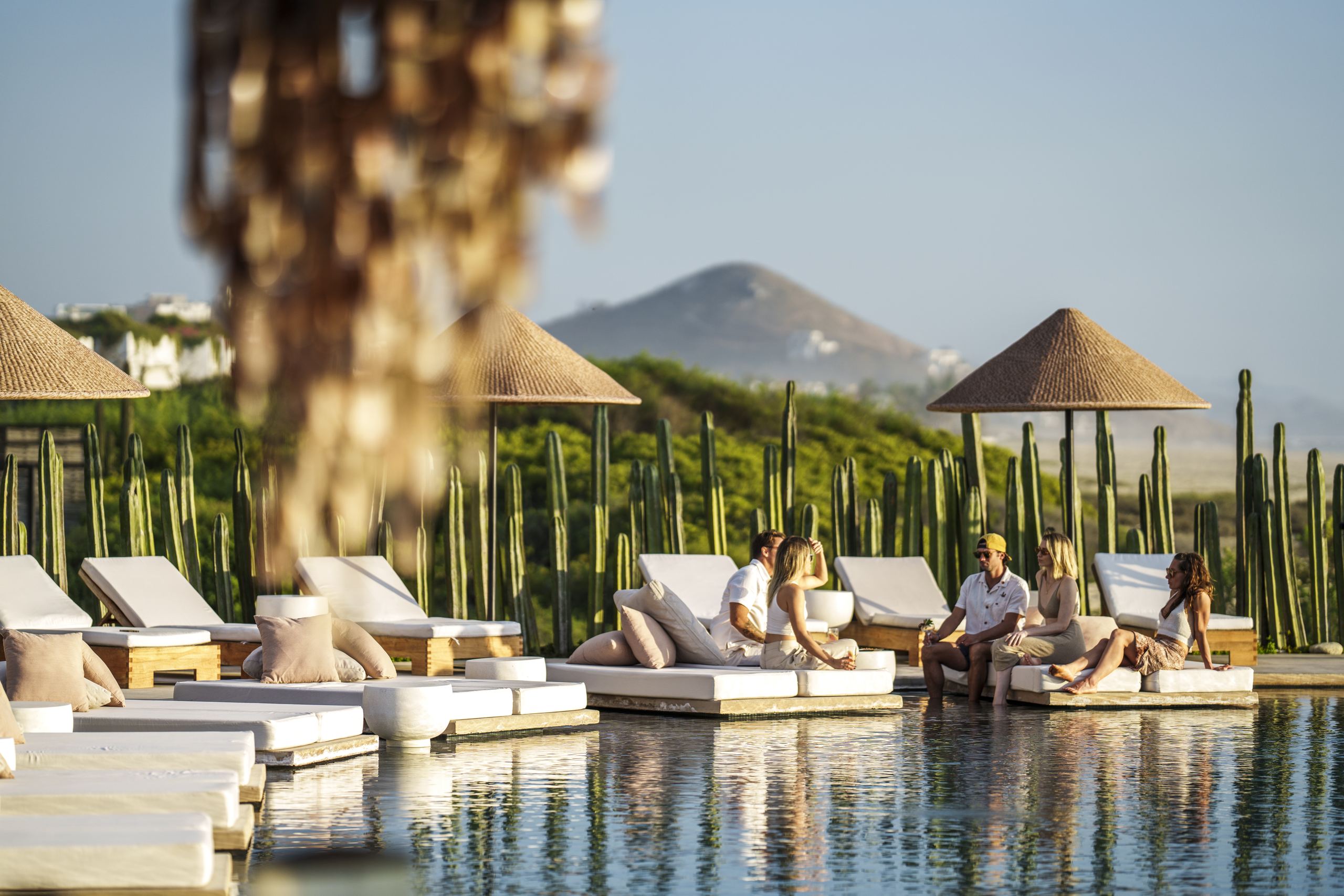 a group of people sitting at the oceanfront infinity pool at Mas Olas Resort