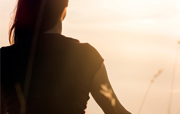 a person looking out at the sun