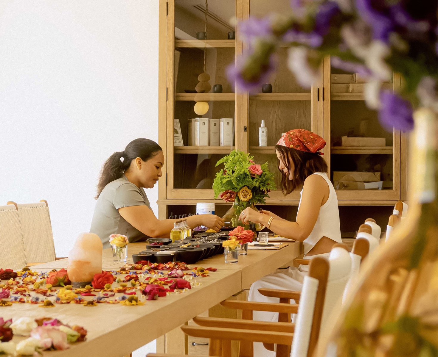 a couple of women sitting at a table with flowers