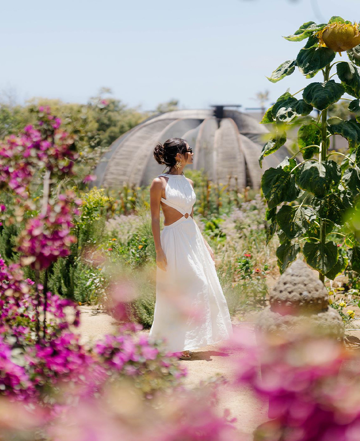a woman in a white dress in a garden