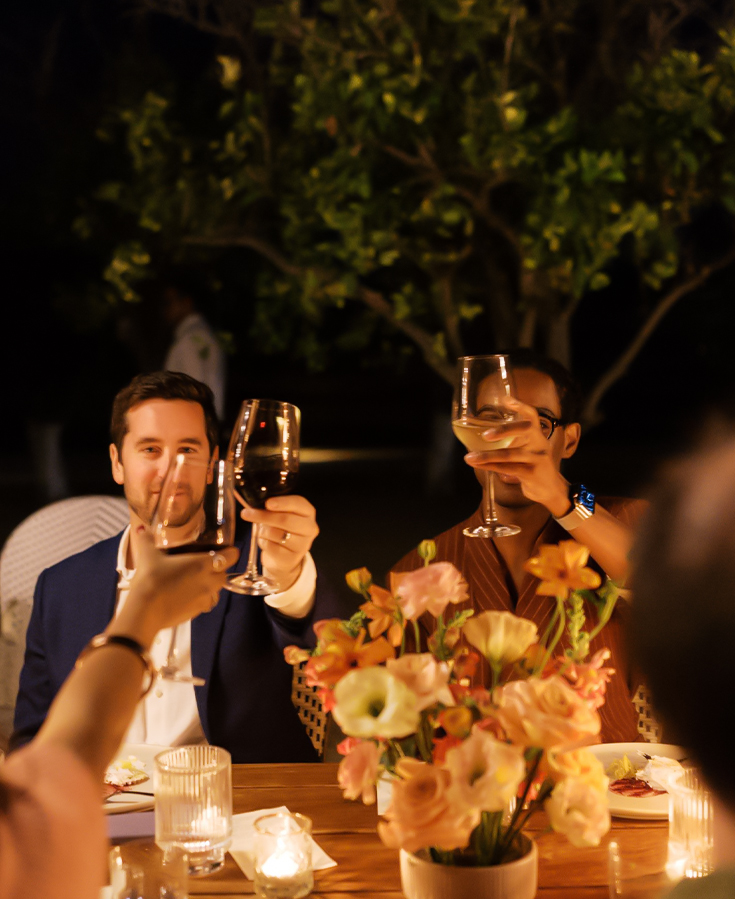 a group of people holding wine glasses at a table