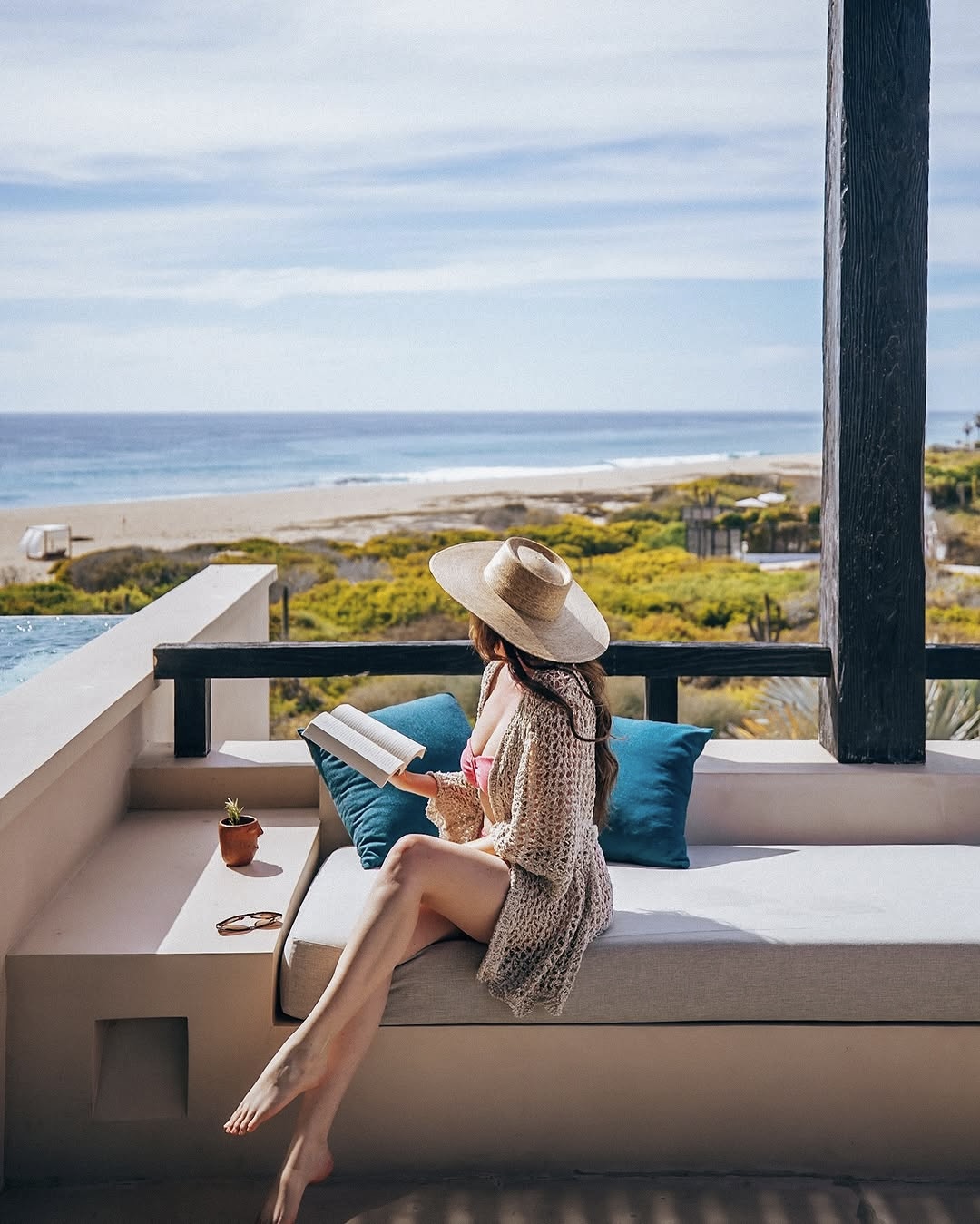 a woman sitting at a Mas Olas resort ocean view room in Todos Santos