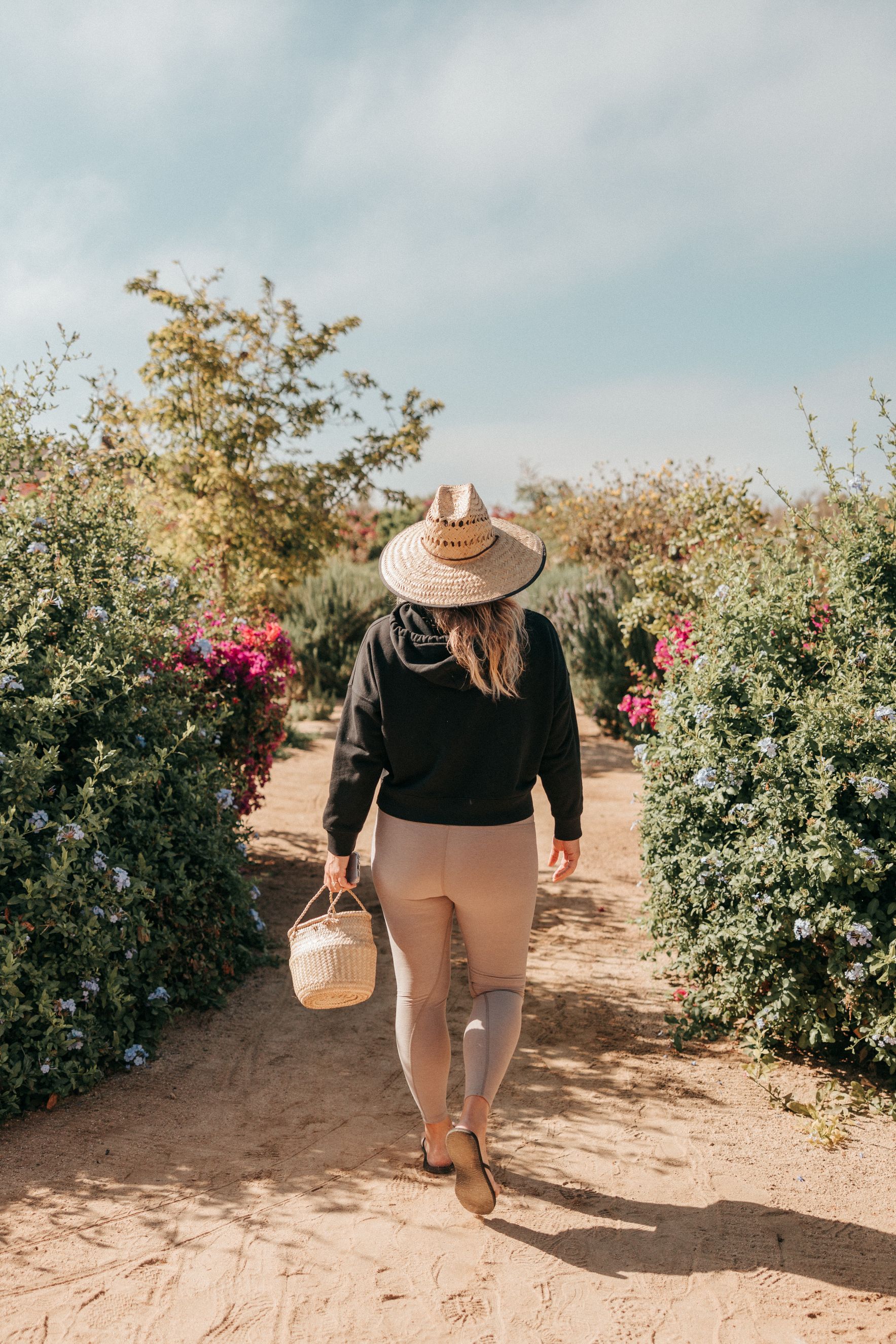 a woman walking through the gardens at Mas Olas wellness resort