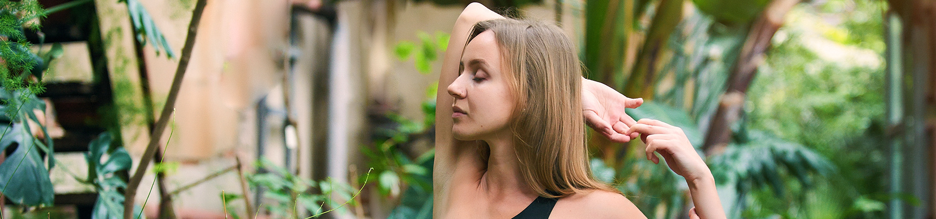 a woman doing yoga with lots of green trees around her