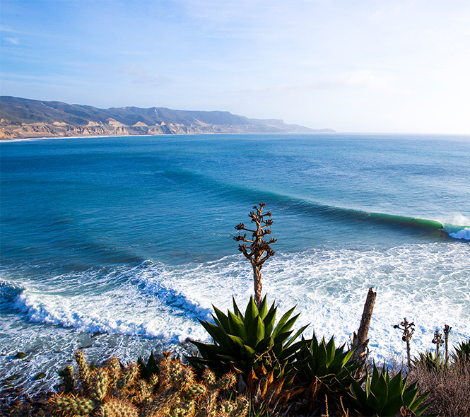 aerial view of the ocean and waves crashing onto shore