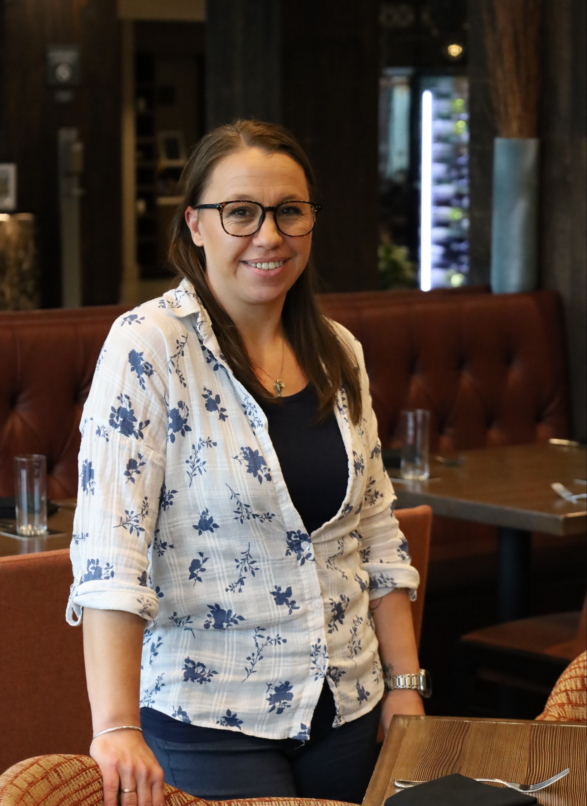 a woman in glasses smiling