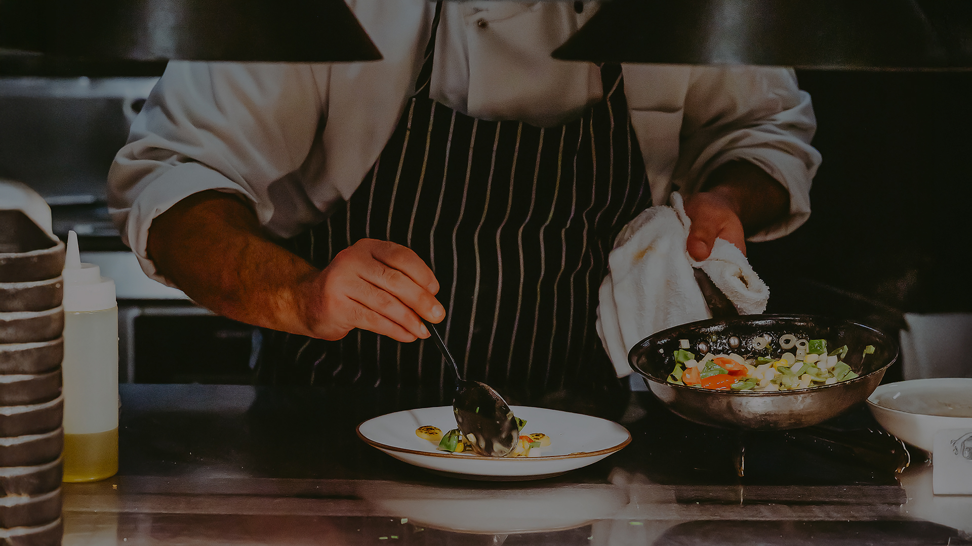 a person in a black and white striped apron cooking