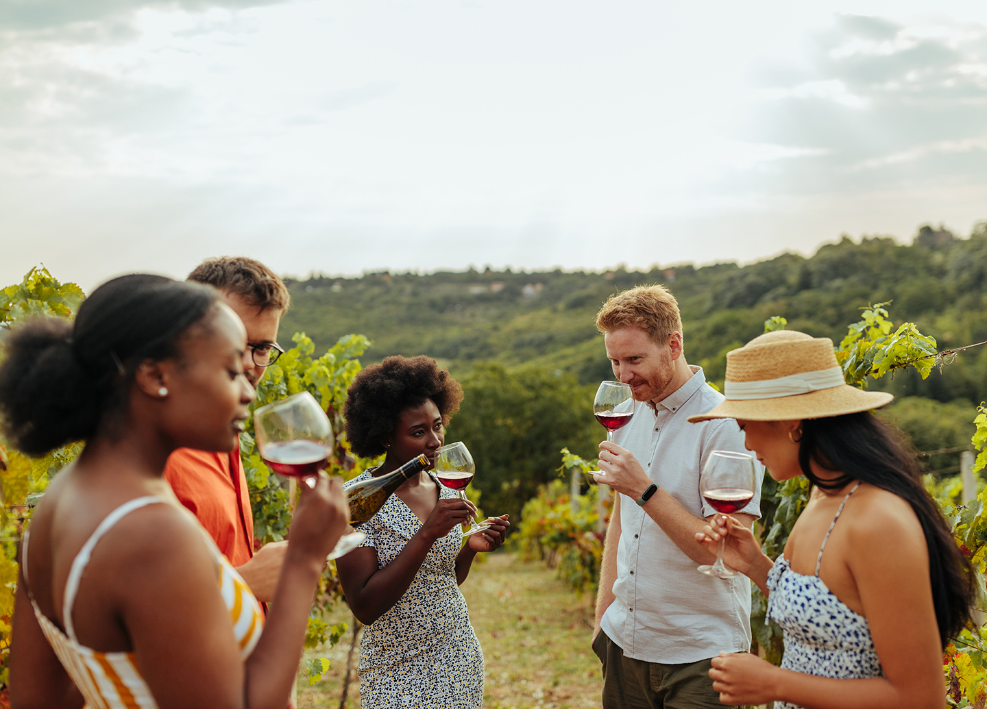 a group of people drinking wine in a vineyard