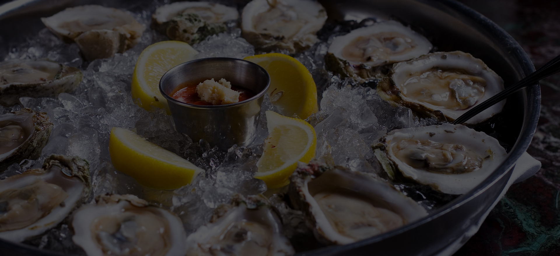 a plate of oysters with lemons and sauce